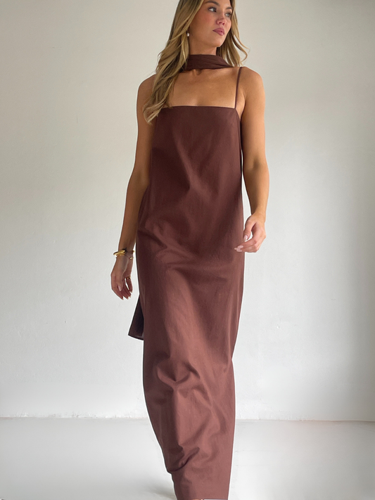 By Nicola Ivy maxi dress in chocolate brown cotton-linen with straight neckline, side slit, column style and chiffon neck tie, ideal for weddings and summer events.