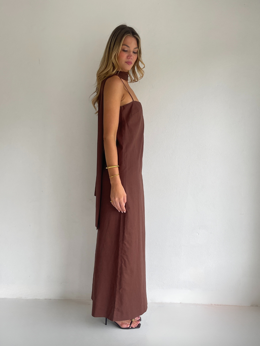 By Nicola Ivy maxi dress in chocolate brown cotton-linen with straight neckline, side slit, column style and chiffon neck tie, ideal for weddings and summer events.