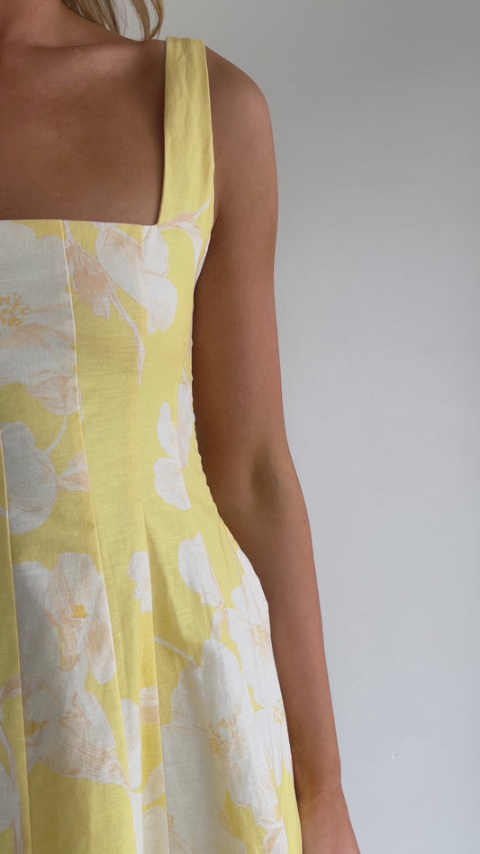 By Nicola Milly mini dress in amarilla flor yellow floral print in cotton linen with  straps and flowy hem, perfect for daytime events and summer occasions. Exclusive to Coco & Lola